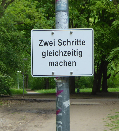 Schild mit folgender Anweisung: Zwei Schritte gleichzeitig machen.