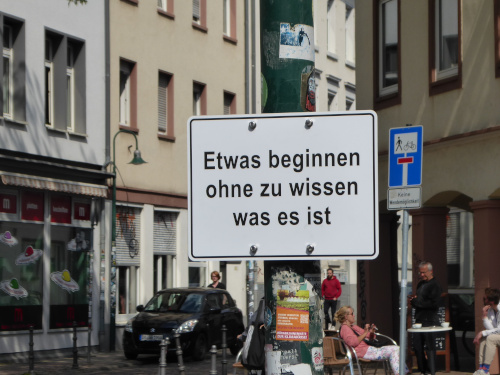 Schild mit folgender Anweisung: Etwas beginnen ohne zu wissen was es ist.